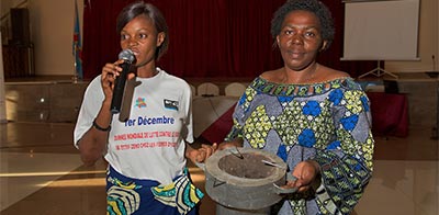 Josephine Malimukono with Joyce, giving clean energy presentation of stove to improve women's access to energy and reduce the risk of gender based violence associated with collecting wood.