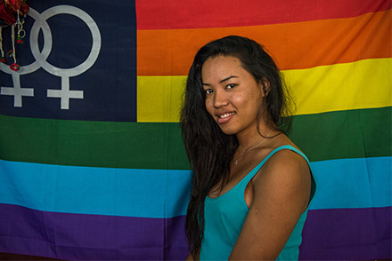 Swastika in front of a rainbow flag, with two linked women symbols