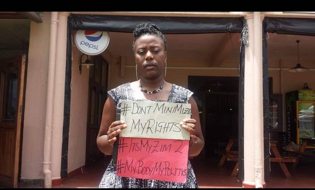 Winnet Shamuyarira holidng up a sign that reads #DontMinimizeMyRights #ItsMyZim2 #MyBodyMyPolitics