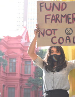 Disha Ravi holding a sign that says Fund Farmers not Coal