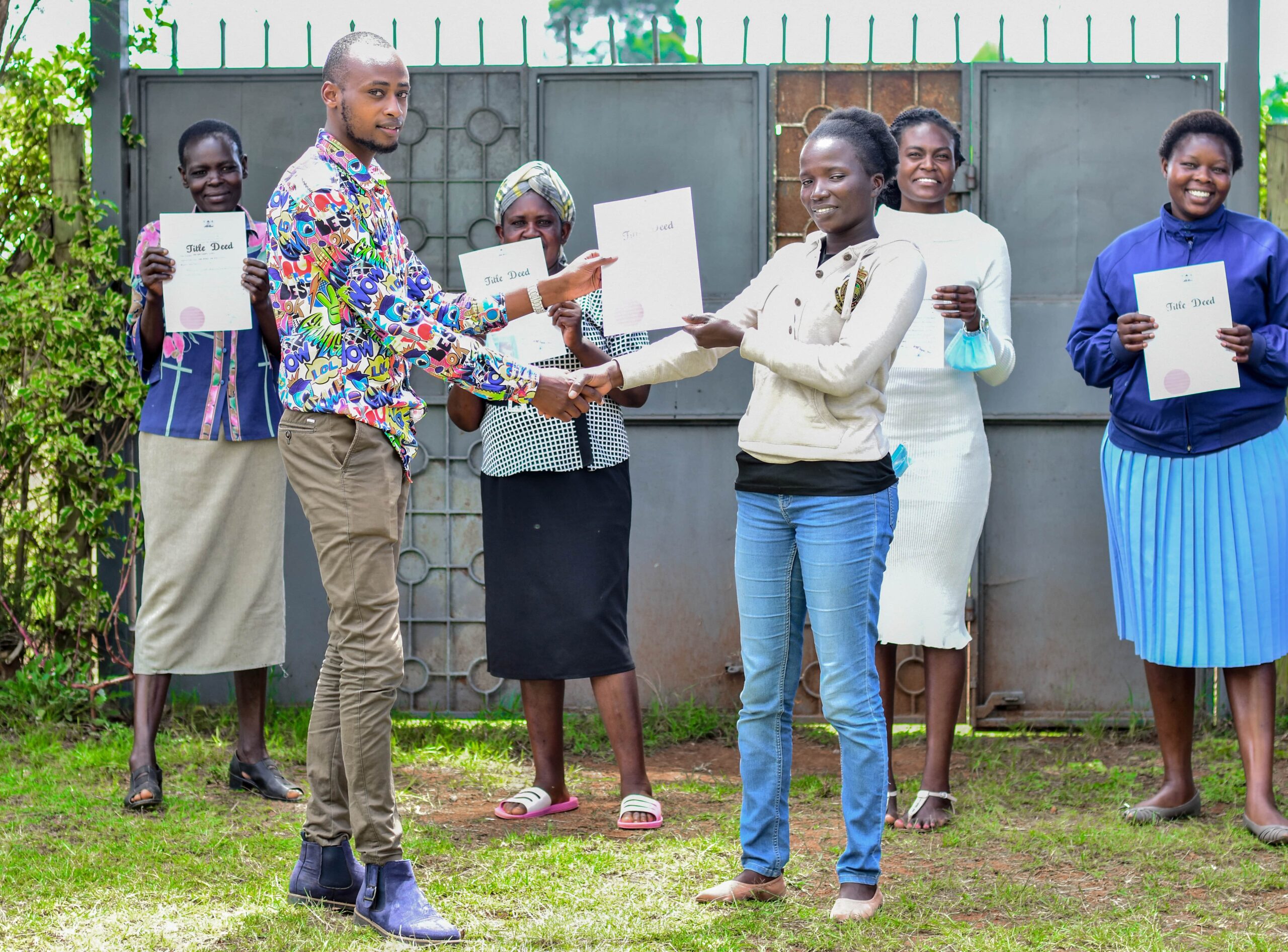 Lamu County Deputy Land registrar-Maswere Juma presenting Boni and Bajuni minority women with land title deeds in Lamu