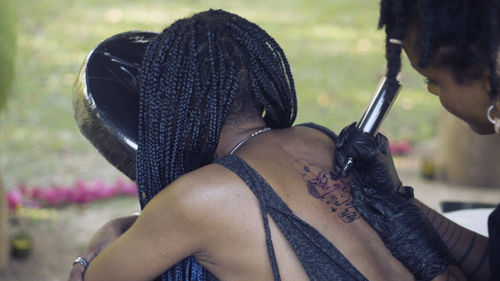 Set in Trinidad, this interdisciplinary, social practice work uses tattooing, performance and storytelling to facilitate healing and to explore the impact of colonialism and slavery on the Black diaspora’s relationship to the land.