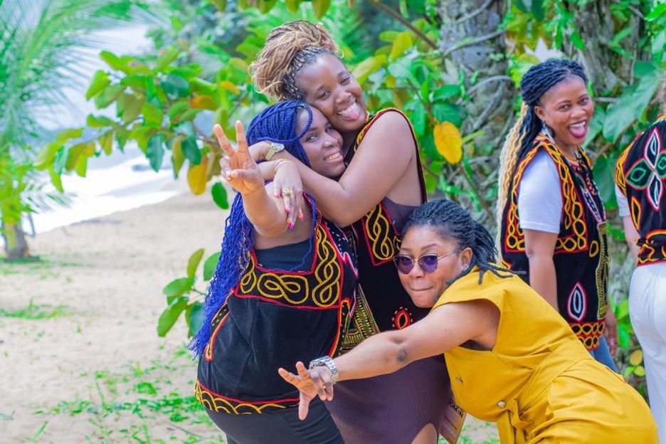 On the last day of the first in-person Movement Committee convening in Kribi, Cameroon, Judicaelle (Consultant, Movement-Led Approach) hugs Hermine (from Benin), while Renée (in yellow), from Cameroon, strikes a pose, and Joséphine, from Guinea, laughs in the background.