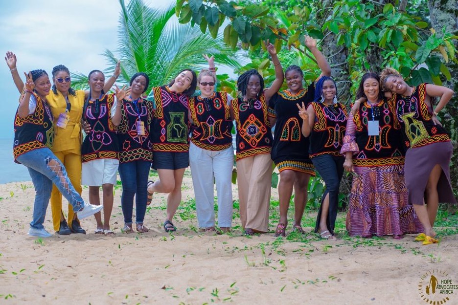 Members of the Movement Committee pose for a group photo with Global Fund for Women team members on the last day of the first in-person Movement Committee convening in Kribi, Cameroon. Caryn and Renée, cohosts of the convening, gifted members with traditional Cameroonian garments.